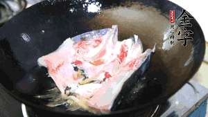 魚頭處理干凈后對(duì)半切開(kāi)，入加熱油的鍋中略煎。